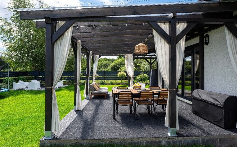 A home addition with a dining table, six chairs, and white curtains